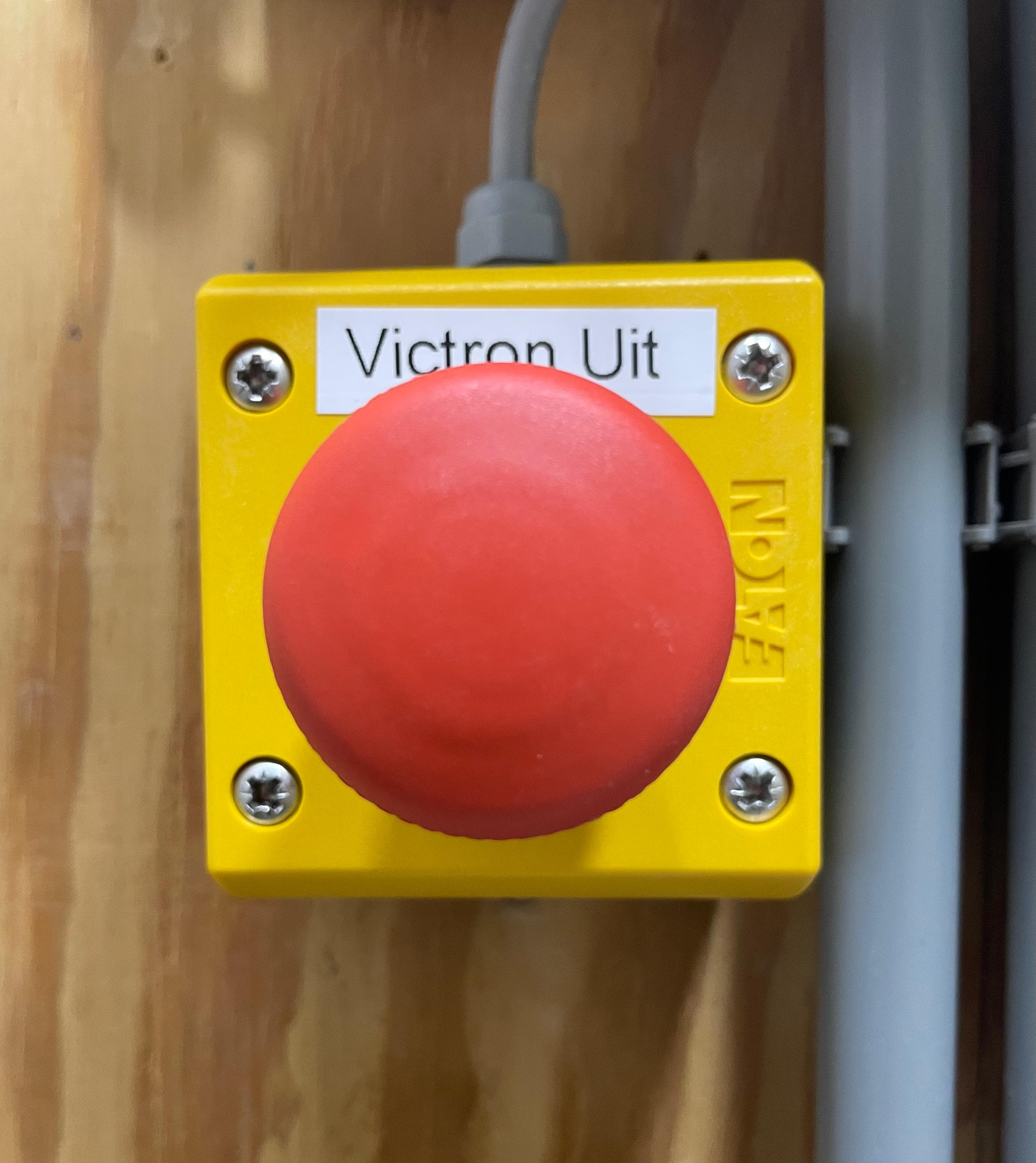 Gele noodstopknop met label Victron Uit